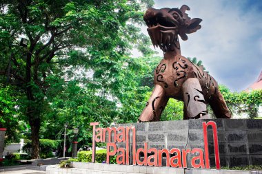 Semarang, Endonezya - 14 Aralık 2025: Semarang şehrindeki Taman Pandanaran kentsel parkına geniş açılı bir bakış açısı, ikonik Warak Ngendok heykeli, kamuya açık oturma alanları ve bulutlu bir gökyüzü altında canlı yeşillikler