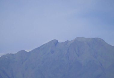 Merkezi Java Endonezya 'da yumuşak bulutlu ve berrak mavi gökyüzü olan volkanik dağ sırtı