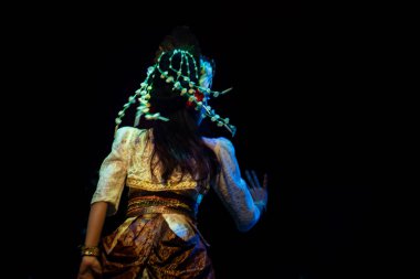 Endonezya Geleneksel Dans Sanatçısı Süslü Kostümler ve Headresler, Arka Bakış Karanlık Sahne El Hareketi, 3 Aralık 2025