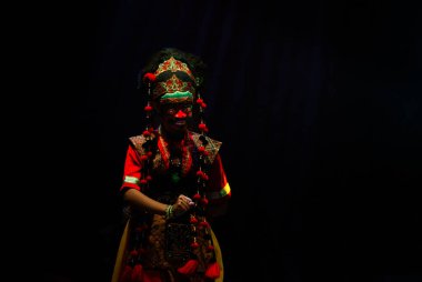 Tari Topeng Geleneksel Maske Karanlık Sahnede Dramatik Sahne Işığı, Süslü Kostüm, Etkileyici Hareketler ve Endonezya Kültür Mirası Performansı