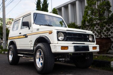 Üç Çeyrek Açı Beyaz Klasik SUV Jimny Katana Sarı Çizgili Şehir Caddesi Yogyakarta, Endonezya, 6 Nisan 2024