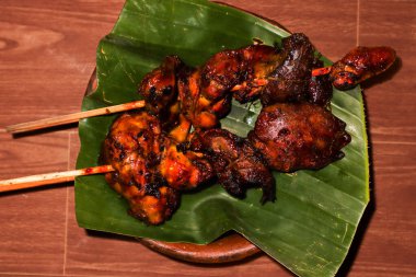 Muz Yaprağı ve Clay Tabağı, Geleneksel Endonezya Satay Ati Ampela Bakar, Egzotik Asya Mutfak Mutfağı Fotoğrafları üzerine servis edilen ızgara Tavuk ciğeri ve tatlı soya soslu Şiş.