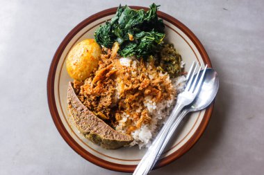Endonezya 'dan Nasi Rames Padang Biftek Ciğeri, Kaynamış Yumurta Gulai ve Gümüş Çatallı Cassava Yaprağı Gri Arka planda, Otantik Asyalı Karışık Pirinç Mutfak Seti, Gastronomi Üst Görünüm