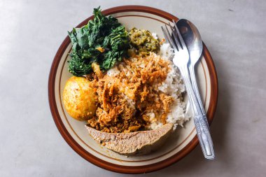 Endonezya Nasi Rames Padang 'ın tam porsiyon sığır ciğeri, yumurta gulai ve çatal dahil Cassava Yaprağı, geleneksel karışık pirinç gri masa, Asya Gastronomisi Üst Görünümü