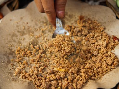 Kahverengi kağıt üzerinde metal kaşıkla ezilmiş fıstıkları klozete yakın tutmak, geleneksel Endonezya Pekmezi Baharatı Market Stall, Otantik Mutfak Hazırlama Arkaplanı