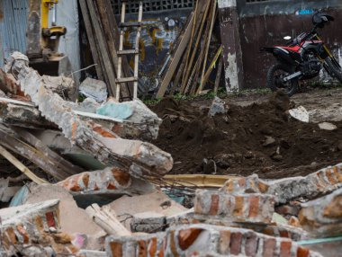 Kırık Beton Duvarı yıkıntıları ve Yıkım Alanındaki Kırmızı Tuğla Molozları, Şehir Yenileme ve Ev Tahliyesi Yapısı, Kazıyıcı 'nın Arkaplanda Çalışmasıyla Parçalanmış Yapı