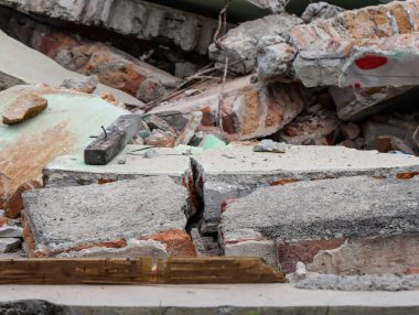 Destroyed Concrete Wall Rubble with Exposed Iron Rebar, Shattered Red Brick Debris from War Conflict or Urban Eviction, Ruined Building Structure After Demolition or Disaster