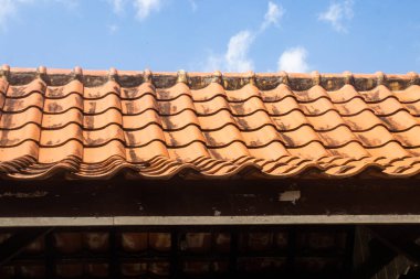 Geleneksel Mavi Gökyüzü Arkaplanı ve Ahşap Destek Yapısına sahip Turuncu Clay Çatı Döşemeleri Mimarisi