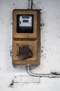 Sanayi Binası Dış ve Kafe Dekorasyonu için Beyaz Grungy Duvarı 'na asma kilitle asılmış Eski Klasik Analog Elektrik Ölçüm Kutusu