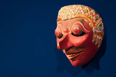 Otantik Endonezya Geleneksel Tahta Maske Karakteri, Wayang Topeng 'in Mavi Arkaplan, Etnik Asya Kültürü ve El Sanatları Sanat Süslemesi Üzerine El oyması Beyaz Yüz Heykeli