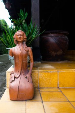 Sarı Bahçe 'de Geleneksel Kebaya' da Terracotta Kadın Heykeli, Sanggul 'un Etnik Ev Dekorasyonu ve Kültürel Sanat Süslemesi için Kuaförü Sanggul Saç Saçlı Klasik Clay Heykeli