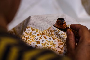 Sanatçı Eli 'nin Aşırı Kapanışı Geleneksel Canting Aracı ve Kumaş, Miras Batik Tekstil Tasarım Süreci ile Karmaşık Örnekler Çiziyor