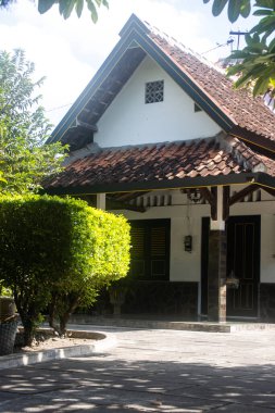 Büyük Yeşil Ağaç ve Beton Kapı Sütunları ile Gölgeli Konut Bahçesi, Clay Tile Çatı ve Şekli Güneş Işığı Çatı ve Taş Pavyonu Geleneksel Asya Evi