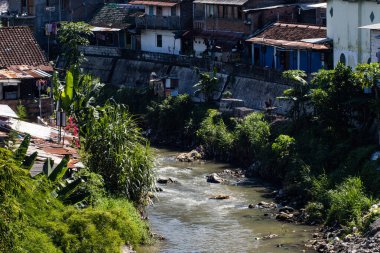 Güneydoğu Asya 'da Toplu Kentsel Konut Alanı ve Beton Duvar Yemini Yeşil Bitkiler ve Geleneksel Evleri ile Tropik Nehir Akıyor