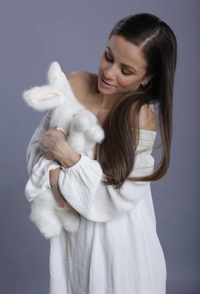 Schattige brunette en een pluche bunnie — Stockfoto