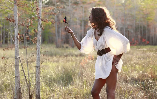 Girl plays with a butterfly in the woods — Stock Photo, Image