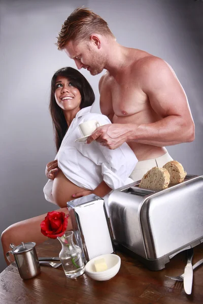 Pregnant couple having breakfast in the kitchen — Stock Photo, Image