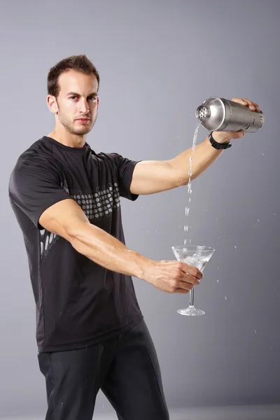 Young man pours himself a martini — Stock Photo, Image