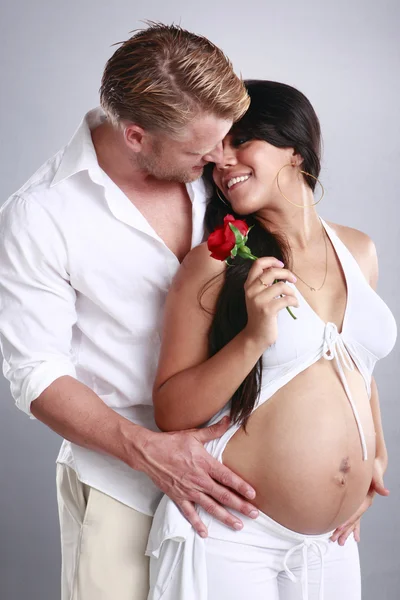 Zwangere meisje en haar vriendje met roos — Stockfoto