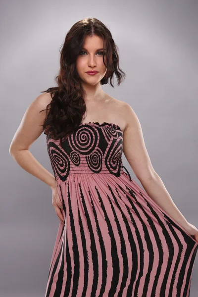 Mooie brunette in elegante roze jurk — Stockfoto