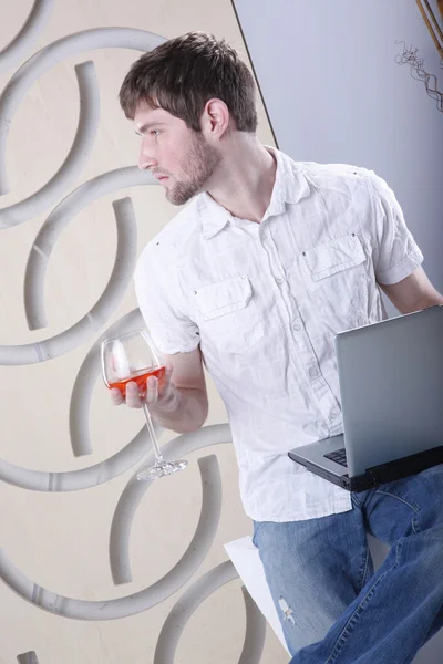 Young man with laptop and drink — Stock Photo, Image