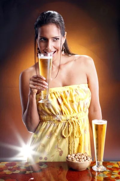 Cute brunette girl with beer and nuts — Stockfoto