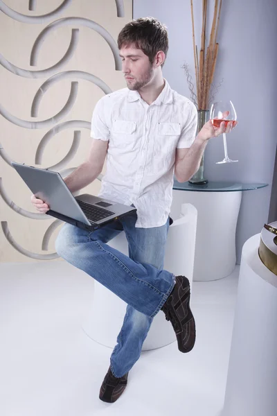 Young man with laptop and drink — Stockfoto