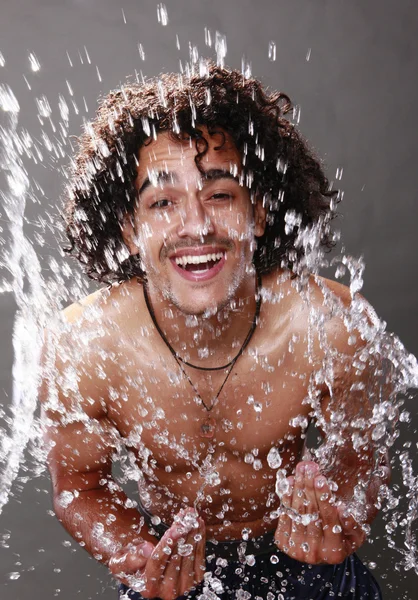 Young man splashes fresh water — Stock Photo, Image