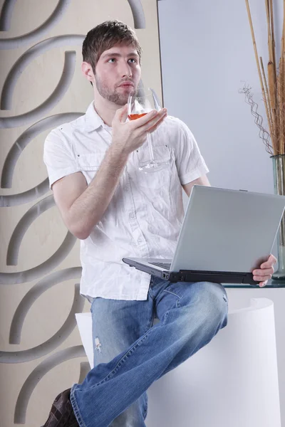 Young man with laptop and drink — 图库照片