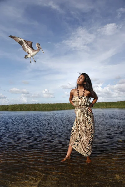 Brunette girl near the lake with bird — Stock Photo, Image