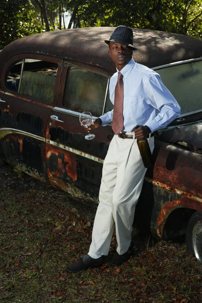 Young ganster with bottle near retro car — Stock Photo, Image