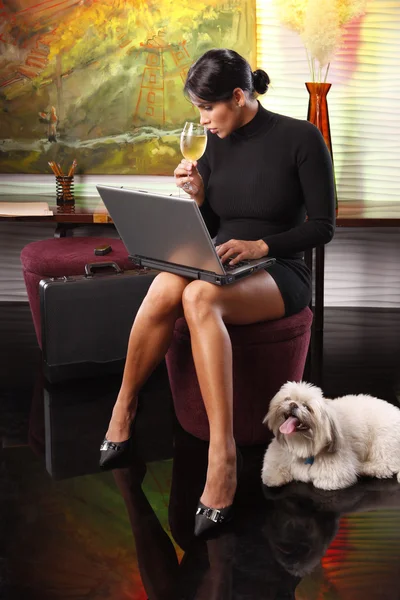 Business woman drinking champagne working on laptop — Stock Photo, Image