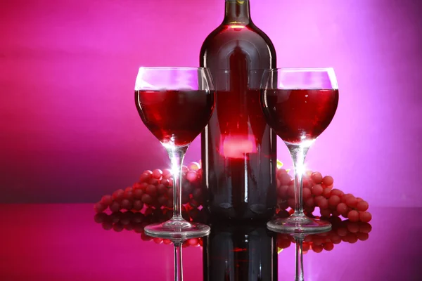 Botella de vino tinto con copas y uvas — Foto de Stock