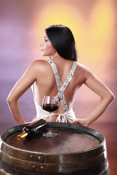 Girl tasting red wine on a cellar's barrel — Stock Photo, Image