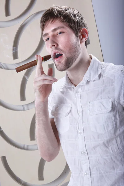 Young businessman smokes a cigar — Stock Photo, Image