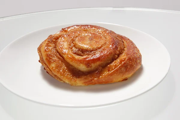Cinnamon roll on white plate — Stock Photo, Image