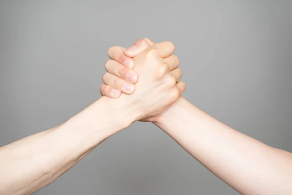 Hand holding hand isolated over gray background - Friendship, Sh