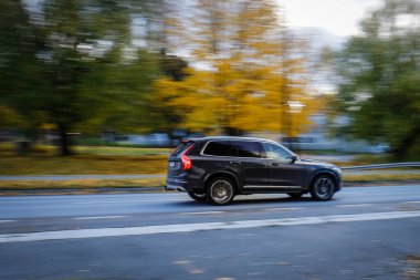 The car captured in motion. Fast movement freezes in photography. Colorful autumn day. The blurred background contrasts with a sharp object in the foreground. clipart