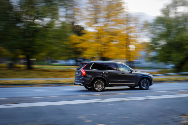 The car captured in motion. Fast movement freezes in photography. Colorful autumn day. The blurred background contrasts with a sharp object in the foreground.