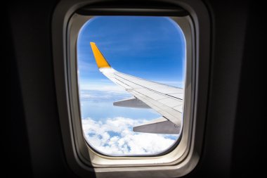 Viewpoint Wing of windows airplane flying above the clouds in the sky clipart