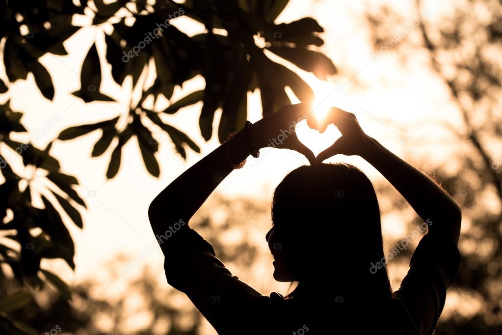 Love shape hand silhouette in sky