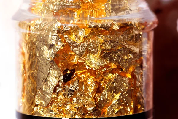 Λαμπερό κίτρινο χρυσό έλασμα σε μπουκάλι, αφηρημένη υφή φόντου. — Φωτογραφία Αρχείου