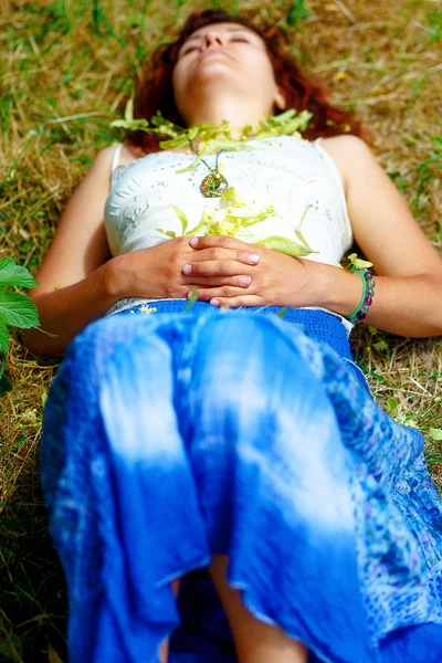 Sonhando menina deitada no prado polvilhado com flores de tília árvore . — Fotografia de Stock