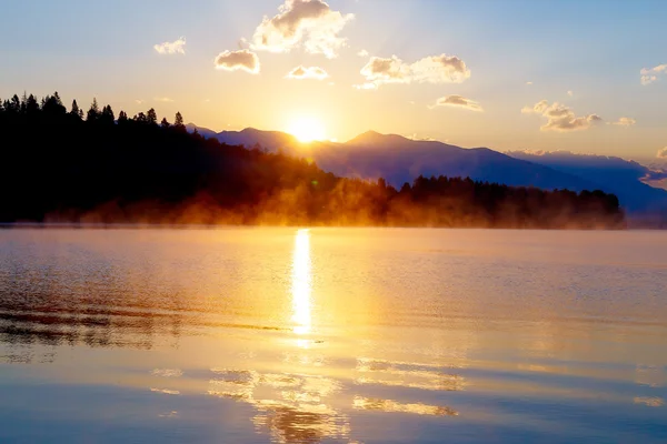 Bela paisagem com montanhas e lago ao amanhecer em tons dourados, azuis e roxos. Eslováquia, Europa Central, Liptov . — Fotografia de Stock