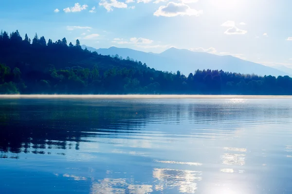 Прекрасне озеро з горами на задньому плані на сході сонця . — стокове фото
