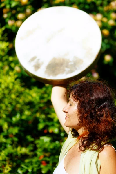 Menina segurando um tambor quadro xamânico em sua mão na natureza . — Fotografia de Stock