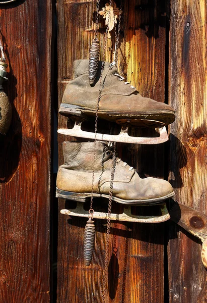 Antique old style retro object assemblage on a wooden wall, rustic stile. Old skates. — Stock Photo, Image