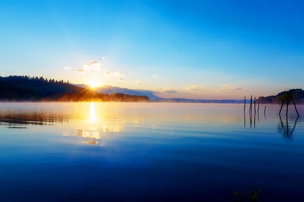 Piękny krajobraz z góry i jeziora o świcie w odcieniach złota, niebieski i fioletowy. — Zdjęcie stockowe