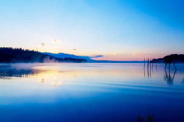 Wunderschöne Landschaft mit Bergen und See im Morgengrauen in goldenen, blauen und violetten Tönen. Slowakei liptovska mara, in der Region liptov. — Stockfoto