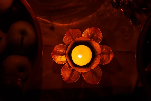 Schöne bezaubernde Lotusform Kerzenleuchter mit brennender Kerze. — Stockfoto